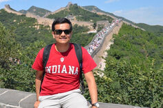 Study Abroad student sits at Great Wall of China